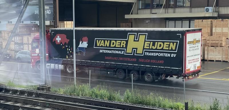 Vrachtwagen met de tekst Van der Heijden Internationale Transporten BV geparkeerd op een industrieterrein.