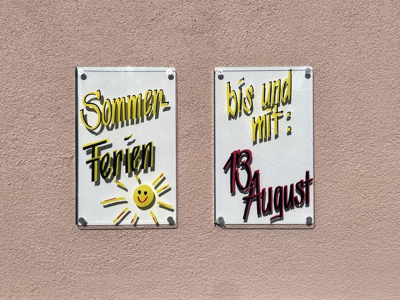 Tekst op twee borden: links 'Sommer-Ferien' met een getekende zon, rechts 'bis und mit: 13 August'.